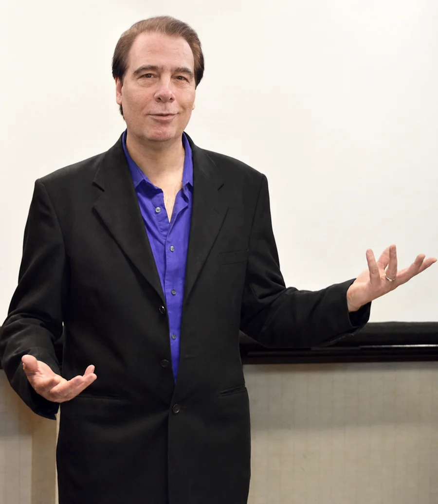 Toby Martini presenting with open hands in front of a projection screen.